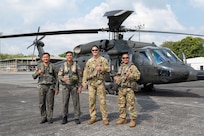 Philippine Air Force Sgt. Julius Chun Manasan, left, mechanic assigned to the 205th Tactical Helicopter Wing; U.S. Army 1st Sgt. Christopher Pacheco, center left, senior mechanic and standardization instructor assigned to the Hawaii Army National Guard; Philippine Air Force Lt. Col. John Paul Delgado, center, commander of the 210th Tactical Training Squadron; and U.S. Army Maj. John Worthington, right, Army Aviation Support Facility commander, standardization pilot and instrument examiner assigned to the Hawaii Army National Guard, pose for a photo in front of a Philippine Air Force S-70i Black Hawk helicopter during a Rotary Wing Subject Matter Expert Exchange Clark Air Base, Philippines, April 15, 2026.