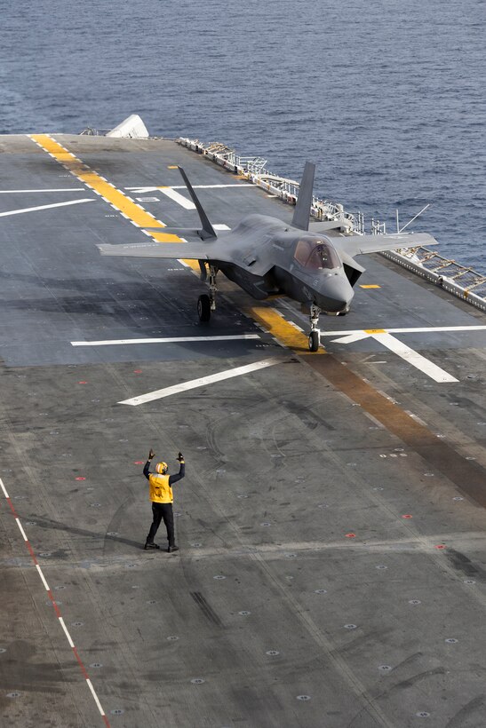 A U.S. Sailor assigned to Wasp-class amphibious assault ship USS Boxer (LHD 4), signals a U.S. Marine Corps F-35B Lightning II attached to Marine Fighter Attack Squadron (VMFA) 122, 11th Marine Expeditionary Unit during flight operations in the Pacific Ocean, March 22, 2026. The 11th MEU is currently underway aboard the Boxer Amphibious Ready Group in the U.S. 3rd Fleet area of operations demonstrating the United States’ long-term commitment to a free and open Indo-Pacific.