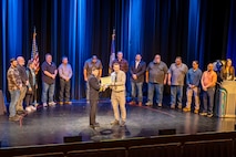 Capt. JD Crinklaw, commander, Puget Sound Naval Shipyard & Intermediate Maintenance Facility, presents Dane Bargerstock, Code 297, with an award in the Engineering or Technical (non-degreed) category, April 22, 2026, during the annual Employee of the Year ceremony at the Admiral Theatre in downtown Bremerton, Washington. (U.S. Navy photo by Jeb Fach)