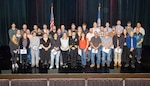 Capt. JD Crinklaw, commander, Puget Sound Naval Shipyard & Intermediate Maintenance Facility, poses for a group picture with the 2025 Employees of the Year during the annual Employee of the Year ceremony at the Admiral Theatre in downtown Bremerton, Washington. (U.S. Navy photo by Wendy Hallmark)