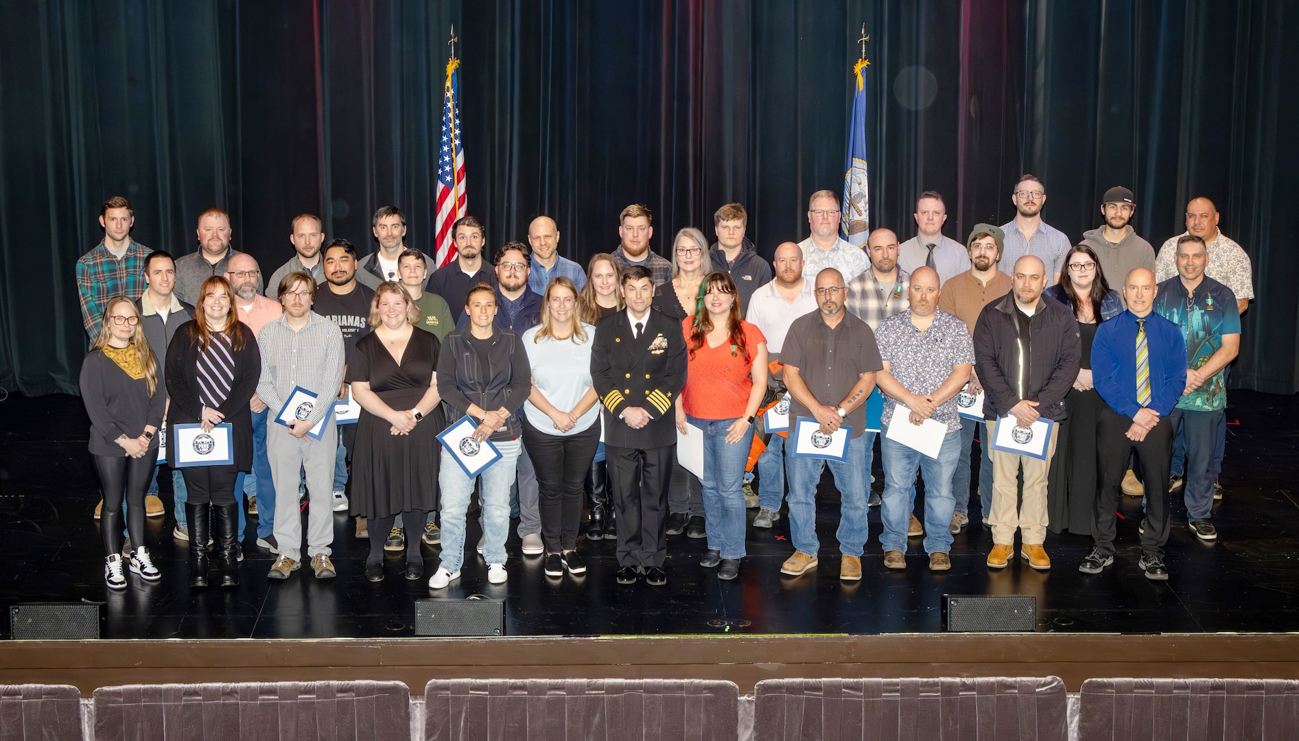 Capt. JD Crinklaw, commander, Puget Sound Naval Shipyard & Intermediate Maintenance Facility, poses for a group picture with the 2025 Employees of the Year during the annual Employee of the Year ceremony at the Admiral Theatre in downtown Bremerton, Washington. (U.S. Navy photo by Wendy Hallmark)