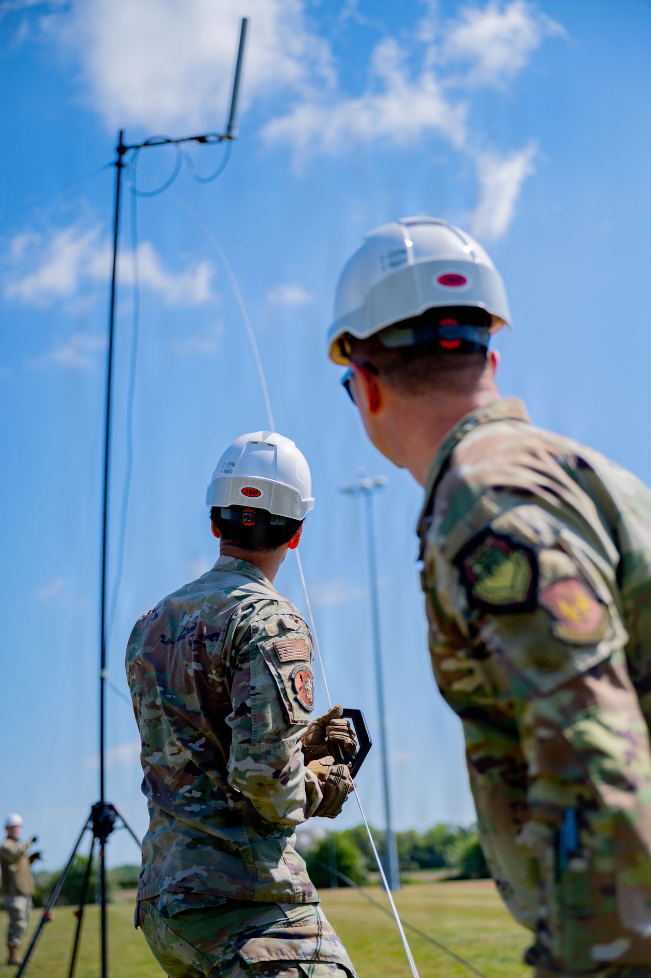 U.S. Air Force Senior Airman Savion Watson, front, 100th Communications Squadron agile combat employment technician, and Col. Steven Byrum, 100th Air Refueling Wing commander, pull the slack on a horizontal dipole antenna during a day in the life integration at RAF Mildenhall, England, April 28, 2026.