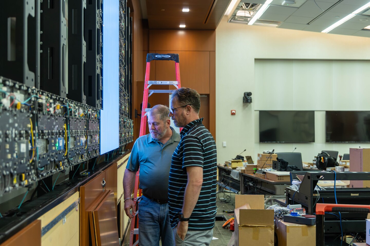 Men looking at new screen wall.