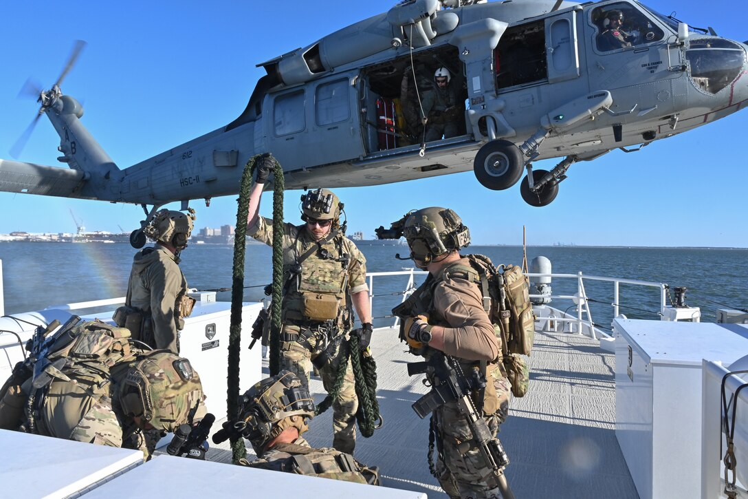 Coast Guard deployable specialized forces assigned to the Coast Guard Maritime Security Team – East stow a fast rope during training with a U.S. Navy MH-60S Seahawk helicopter aircrew from the Helicopter Sea Combat – Squadron 11 (HSC-11) while underway aboard Coast Guard Cutter Richard Snyder (WPC 1127) on the James River in Newport News, Virginia, Oct. 22, 2025. Coast Guard DSF personnel conducted boarding team delivery and fast-rope training with HSC-11 to increase interoperability and enable team member qualification. (U.S. Coast Guard photo by Petty Officer 2nd Class Brandon Hillard)