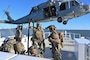 Coast Guard deployable specialized forces assigned to the Coast Guard Maritime Security Team – East stow a fast rope during training with a U.S. Navy MH-60S Seahawk helicopter aircrew from the Helicopter Sea Combat – Squadron 11 (HSC-11) while underway aboard Coast Guard Cutter Richard Snyder (WPC 1127) on the James River in Newport News, Virginia, Oct. 22, 2025. Coast Guard DSF personnel conducted boarding team delivery and fast-rope training with HSC-11 to increase interoperability and enable team member qualification. (U.S. Coast Guard photo by Petty Officer 2nd Class Brandon Hillard)