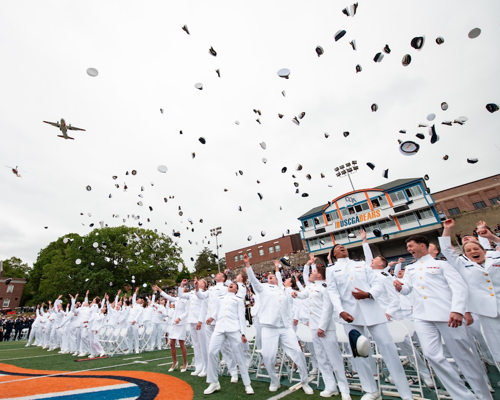 The Coast Guard Academy Class of 2025 throws their combination covers into the air during a flyover at the 144th Commencement Exercises at the Coast Guard Academy, May 21, 2025. The ceremony marks the culmination of the 200-week cadet training program. (U.S. Coast Guard photo by Petty Officer 3rd Class Matt Thieme.)