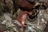A member of the U.S. Air Force’s 794th Communications Squadron applies a new unit patch to an Airman from the 690th Intelligence Support Squadron during a mission

transfer ceremony on Joint Base Anacostia-Bolling, Washington, D.C., May 1, 2026. The ceremony highlighted the merger of the two squadrons and featured patch-swapping between 20 personnel from both units. (U.S. Air Force photo by Senior Airman Shanel Toussaint)