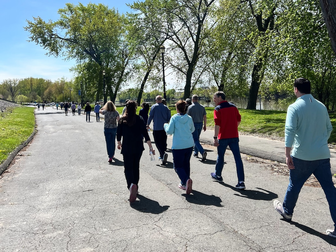 A group walks along a path next to a river