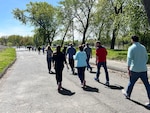 A group walks along a path next to a river