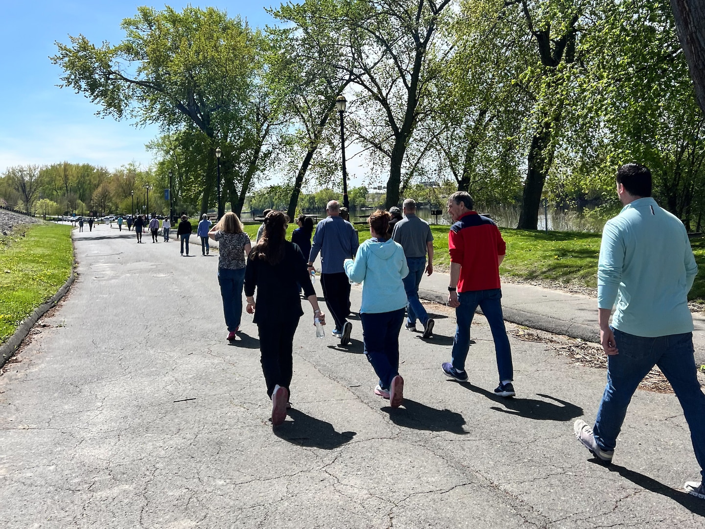 A group walks along a path next to a river
