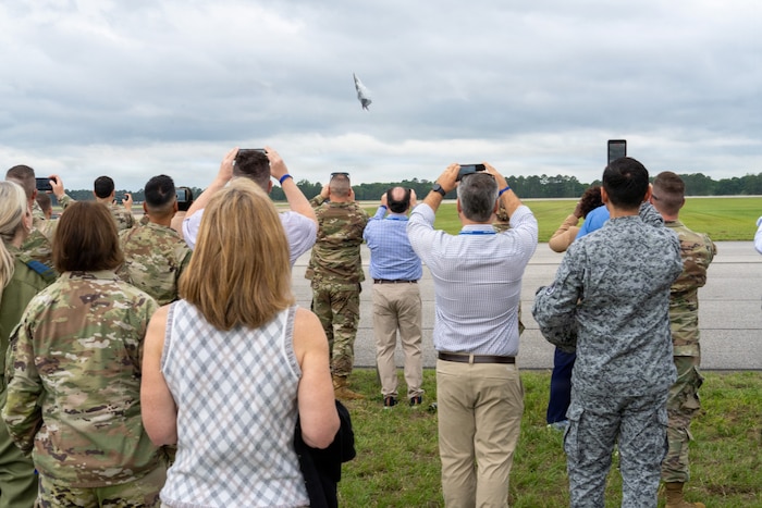 National Security Forum and Gathering of Eagles attendees record an F-22 Demonstration Team aerial performance during an Airpower demonstration at Maxwell Air Force Base, Alabama, May 6, 2026.