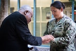 Father Ignatius Madamere blesses the hands of Cmdr. Stacey Swindells during the “Blessing of the Hands” ceremony at Navy Medicine Readiness and Training Command Cherry Point.