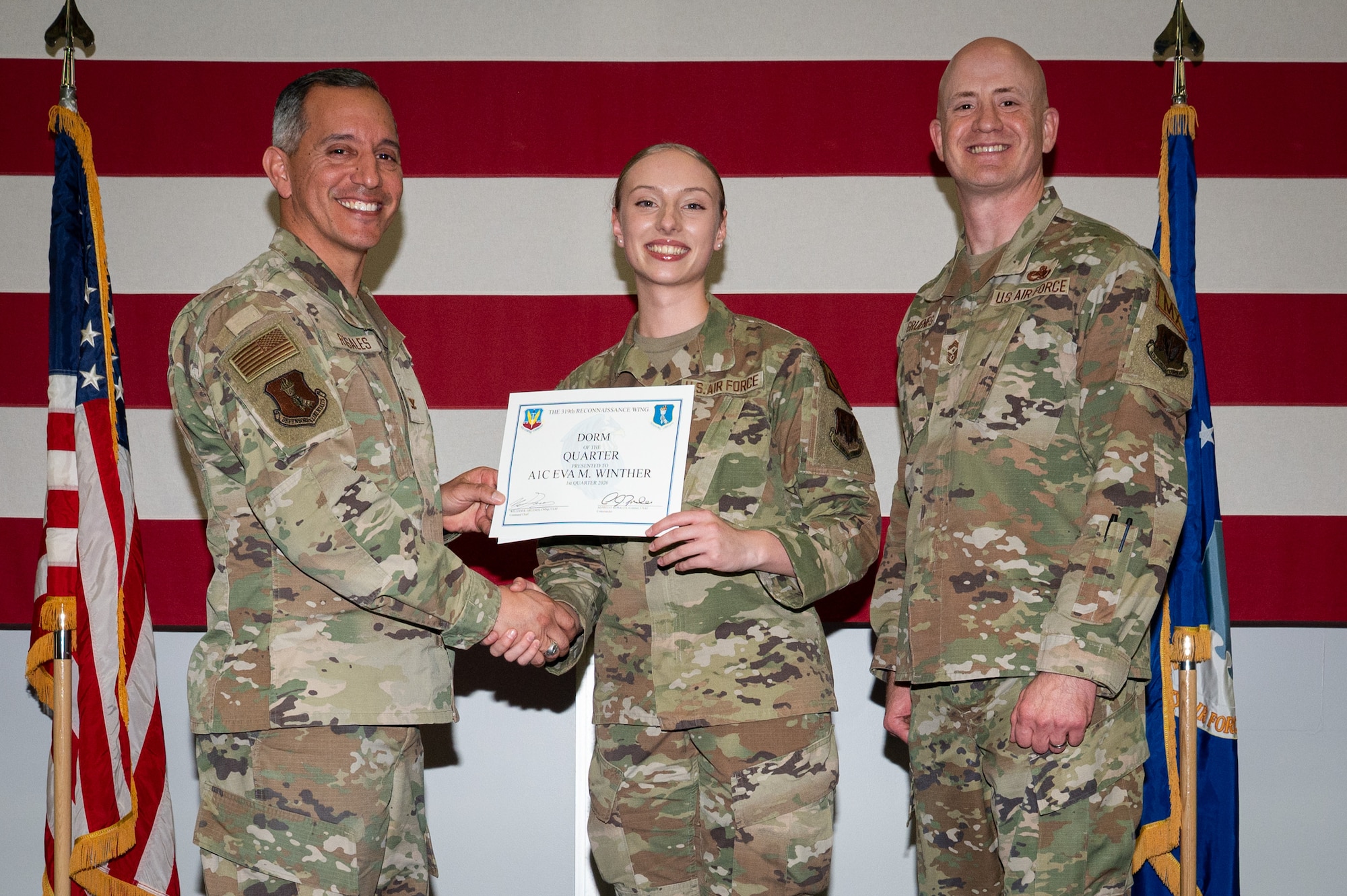 A photo of a group of people stands on a stage holding an award.