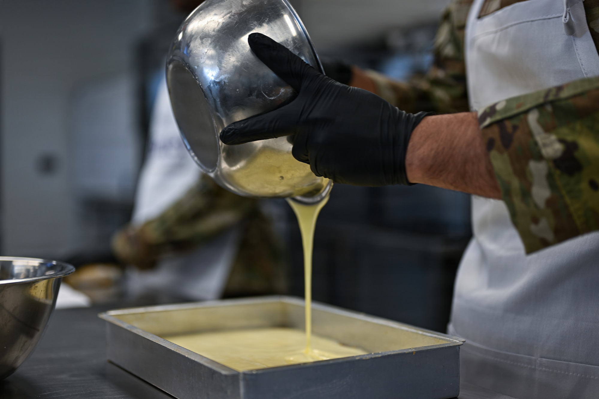 A 22nd Force Support Squadron dining facility Airman pours batter into a pan at the Redler Institute of Culinary Arts in Andover, Kansas, April 28, 2026. The DFAC Airmen participated in a partnered program between Redler and McConnell Air Force Base where they had the opportunity to have expert instruction on two separate recipes. (U.S. Air Force photo by Senior Airman Amelio Brown)
