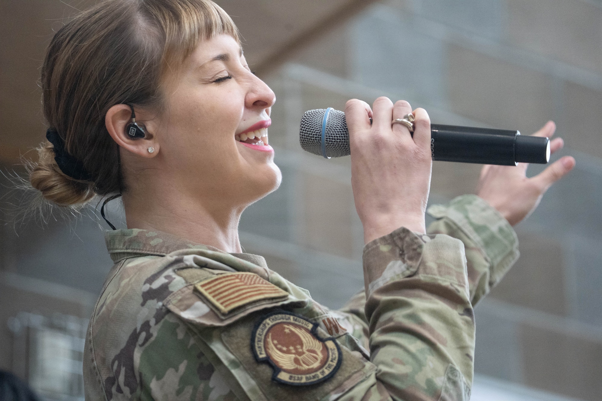 U.S. Air Force Staff Sgt. Courtney Woods, U.S. Air Force Band of the Pacific-Hawaii lead singer, performs for students during their lunch period at Eagle River High School in Eagle River, Alaska, April 22, 2026. The high-energy performance was part of a community relations tour across the state, designed to engage with local youth and celebrate the Month of the Military Child. (U.S. Air Force photo by Airman 1st Class Keola Vischi)