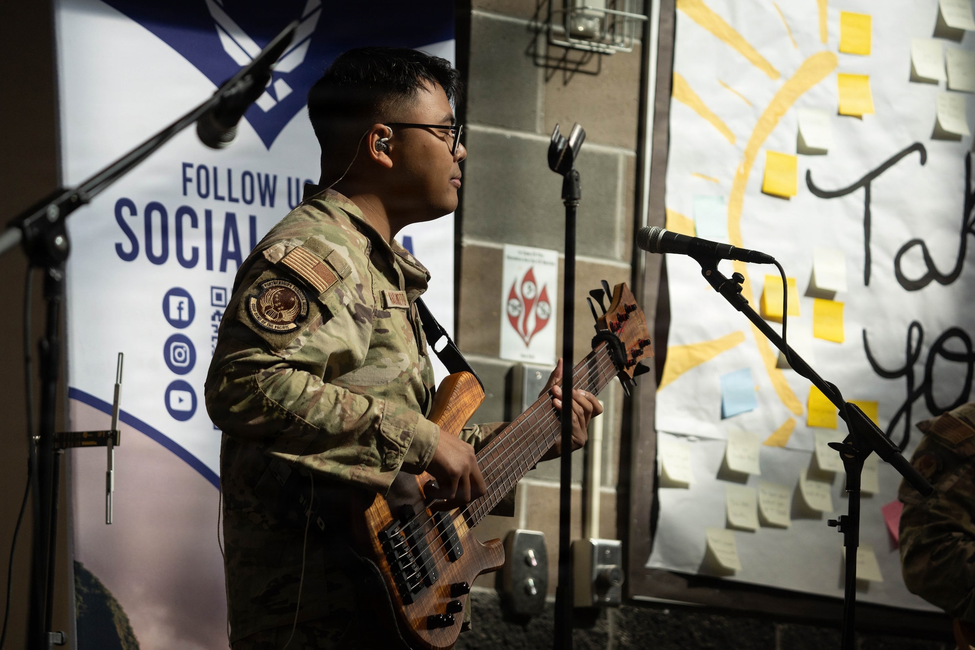 U.S. Air Force Senior Airman Eric Nakamoto, U.S. Air Force Band of the Pacific-Hawaii bass guitarist, plays for students during a lunchtime concert at Eagle River High School in Eagle River, Alaska, April 22, 2026. The high-energy performance provided an opportunity for the musicians to engage with the student body, fostering community relations and celebrating the Month of the Military Child at a school with a high concentration of military dependants. (U.S. Air Force photo by Airman 1st Class Keola Vischi)