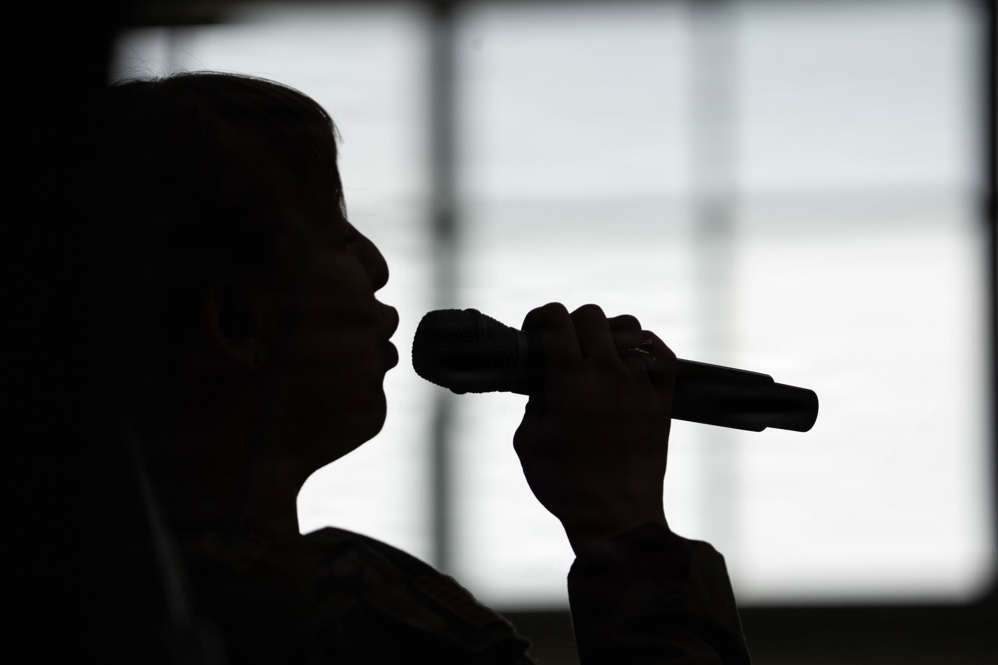 U.S. Air Force Staff Sgt. Courtney Woods, U.S. Air Force Band of the Pacific-Hawaii lead singer performs for students during their lunch period at Eagle River High School in Eagle River, Alaska, April 22, 2026. The performance was part of a community relations tour across the state designed to engage with local youth and celebrate the Month of the Military Child in a school where approximately 50% of the student population are military dependants. (U.S. Air Force photo by Airman 1st Class Keola Vischi)
