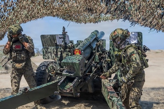 A Philippine Army cannon crewmember, assigned to Eighth Field Artillery Brigade, Artillery Regiment, pulls the cord for an M101 105mm Howitzer during a counter landing live-fire exercise as part of Exercise Balikatan 2026 at La Paz Sand Dunes, Laoag City, Philippines, May 4, 2026.