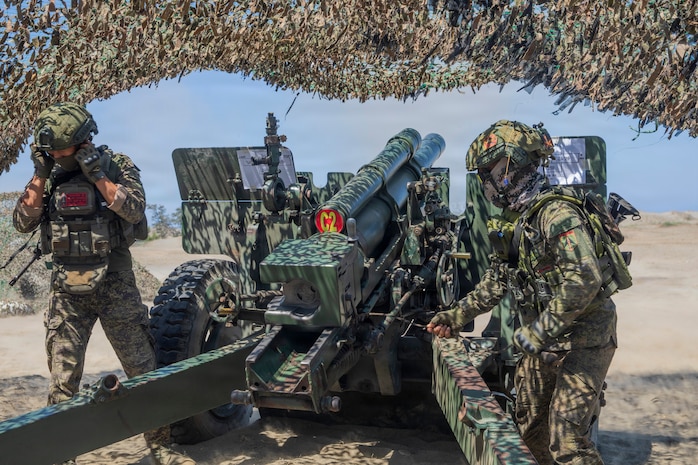 A Philippine Army cannon crewmember, assigned to Eighth Field Artillery Brigade, Artillery Regiment, pulls the cord for an M101 105mm Howitzer during a counter landing live-fire exercise as part of Exercise Balikatan 2026 at La Paz Sand Dunes, Laoag City, Philippines, May 4, 2026.