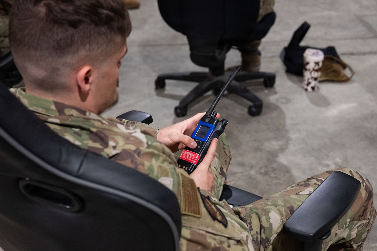 An Airman holds a radio