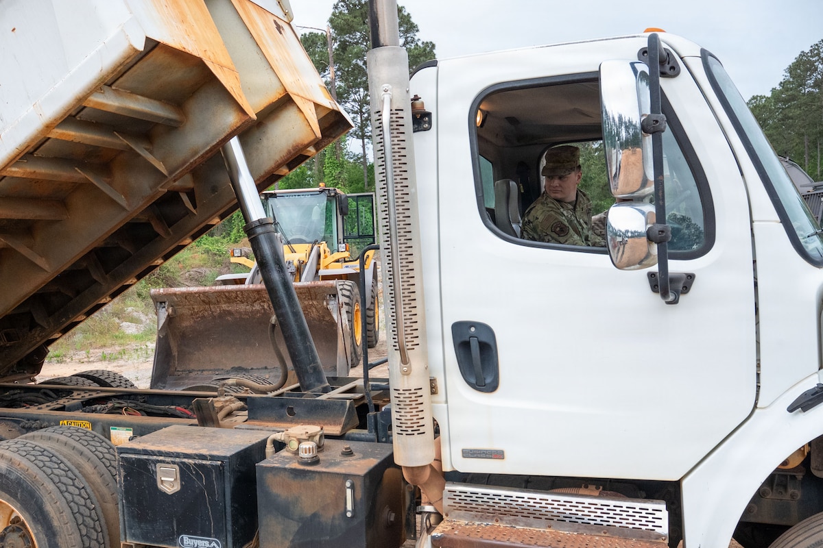 An Airman operates a dump truck