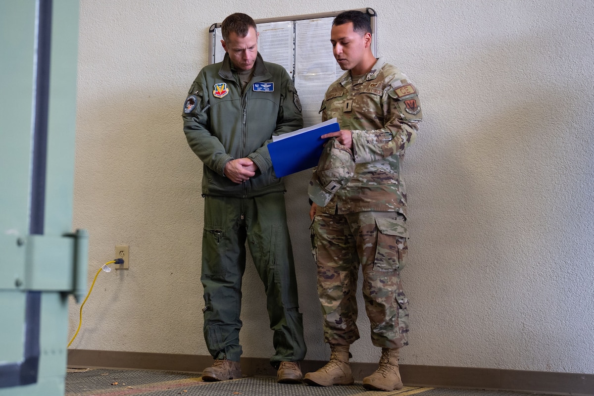 Two airmen look a clipboard