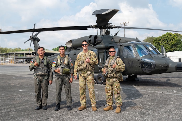 Philippine Air Force Sgt. Julius Chun Manasan, left, mechanic assigned to the 205th Tactical Helicopter Wing; U.S. Army 1st Sgt. Christopher Pacheco, center left, senior mechanic and standardization instructor assigned to the Hawaii Army National Guard; Philippine Air Force Lt. Col. John Paul Delgado, center, commander of the 210th Tactical Training Squadron; and U.S. Army Maj. John Worthington, right, Army Aviation Support Facility commander, standardization pilot and instrument examiner assigned to the Hawaii Army National Guard, pose for a photo in front of a Philippine Air Force S-70i Black Hawk helicopter during a Rotary Wing Subject Matter Expert Exchange Clark Air Base, Philippines, April 15, 2026.