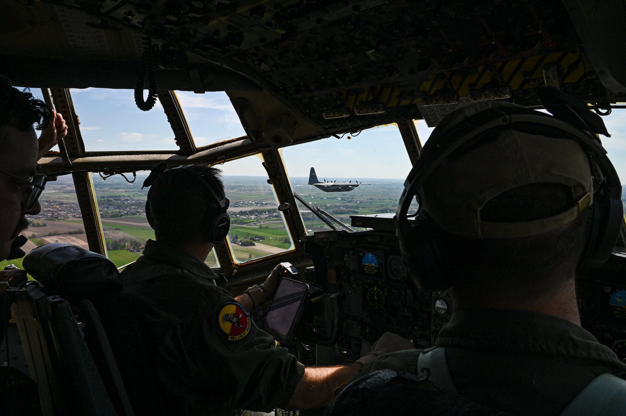 U.S. Air Force Maj. Edwin Fattman, left, and 1st Lt. David Kocher, 180th Airlift Squadron pilots, look over at a C-130H Hercules aircraft from the 139th Airlift Wing, during Hussar Saber 26-1.