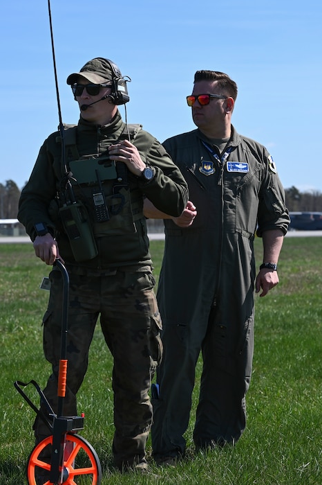 A Polish air force member assigned to the 33rd Airlift Base, left, and U.S. Air Force Lt. Col. Peter Namyslowski, 52nd Operations Group, Detachment 1 commander, look over the flight line during Hussar Saber 26-1.