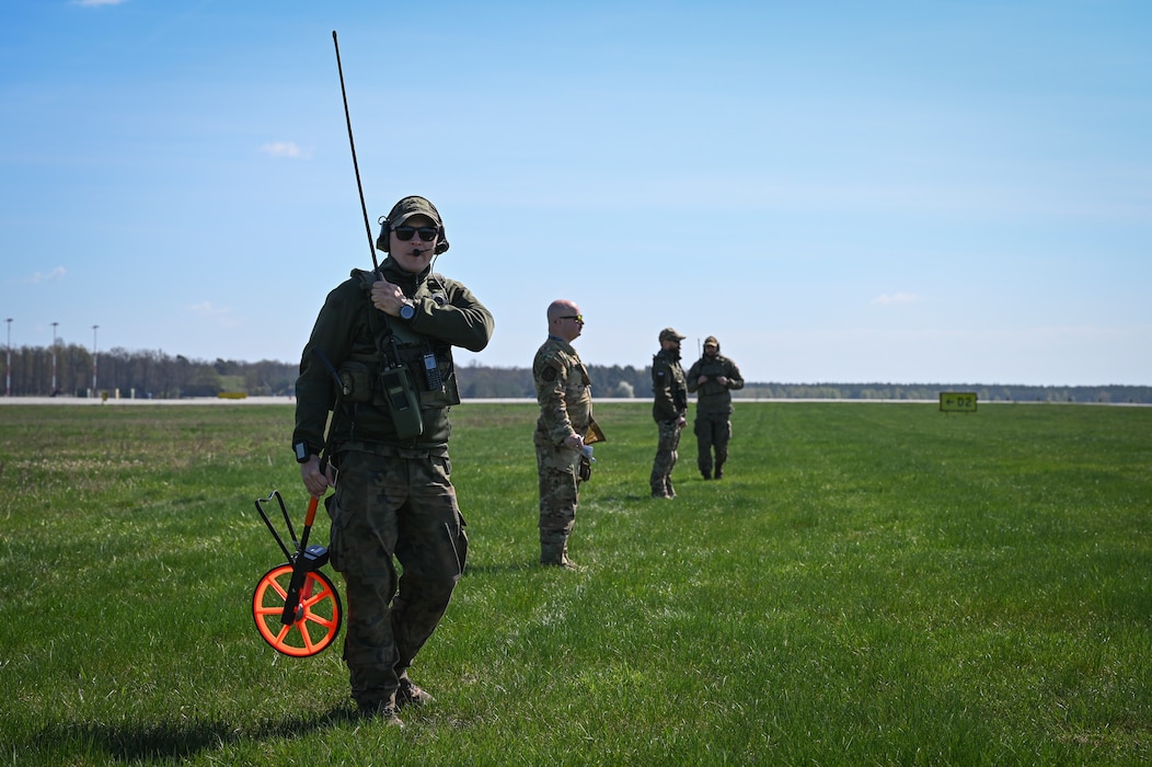 A U.S. Airman assigned to the 139th Airlift Wing and Polish Allies assigned to the 33rd Airlift Base prepare to mark a landing of a C-130H Hercules aircraft from the 139th Airlift Wing, during Rodeo Day in support of Hussar Saber 26-1.