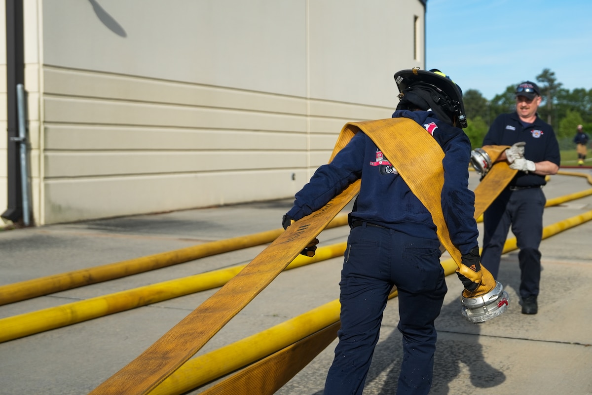 Firefighters pull a faulty hose
