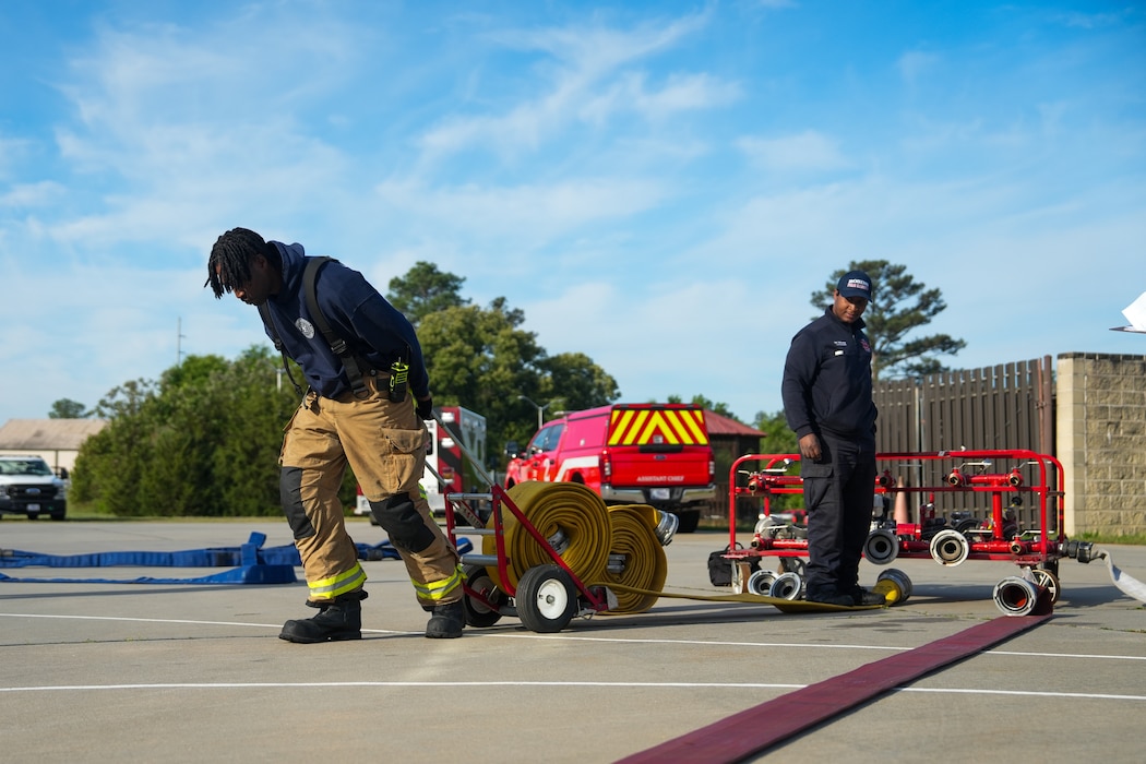 A firefighter pulls a fire hose to unravel it