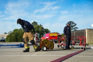 A firefighter pulls a fire hose to unravel it
