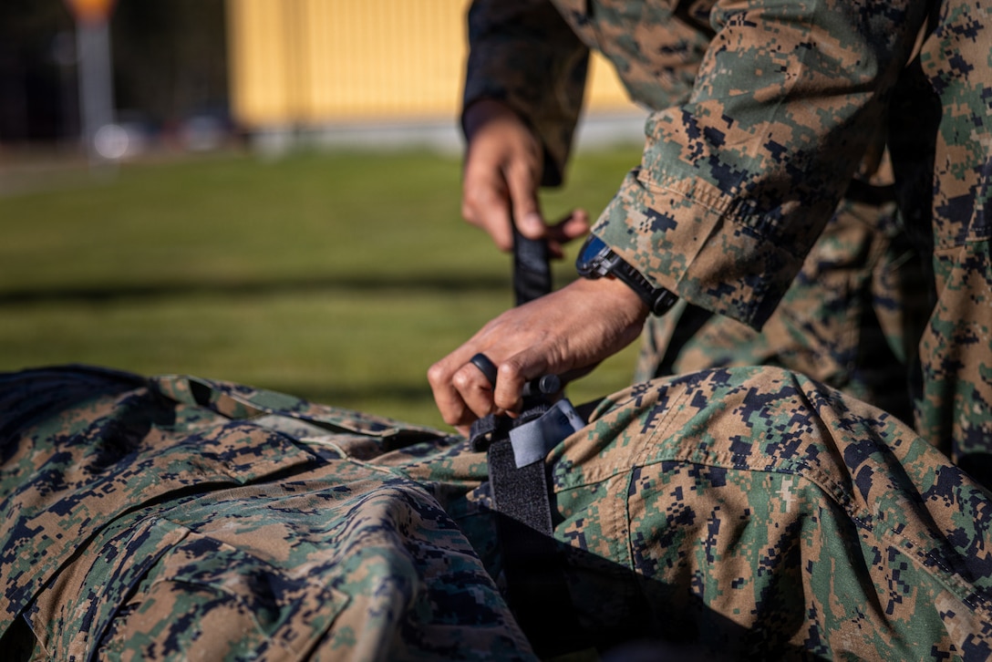 U.S. Navy Hospital Corpsman 2nd Class Tommy Nguyen, right, with Combat Logistics Battalion 24, Combat Logistics Regiment 27, 2nd Marine Logistics Group, demonstrates how to apply a torniquet during exercise Aurora 26 in Kvarn, Sweden, May 1, 2026. U.S. Marines and Sailors with 2nd MLG are participating in exercise Aurora as part of the larger U.S. Army-led Sword 26 series of linked multinational exercises, which directly supports NATO's Eastern Flank Deterrence Initiative concept, validates defense plans, builds a unified lethal force, and strengthens deterrence. Nguyen is a native of California. (U.S. Marine Corps photo by Lance Cpl. Brady V. Hathaway)