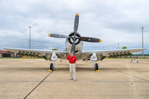An eagle standing in front of a prop airplane