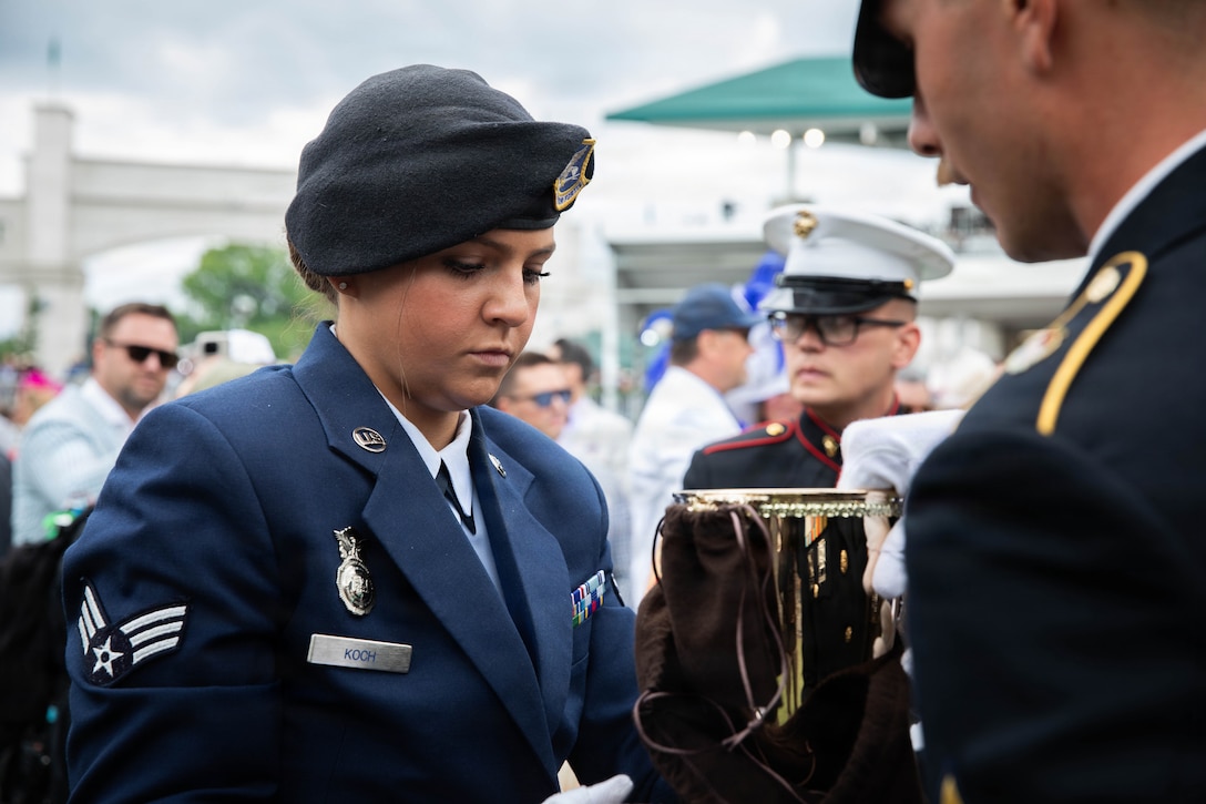Staff Sgt. Jonathan Miller of the 617th Military Police Company and Senior Airman Rebecca Koch of the 123rd Security Forces Squadron prepare to secure the winner's trophy for transport off the Paddock at the 152nd running of the Kentucky Derby at Churchill Downs in Louisville, Kentucky, May 2, 2026.