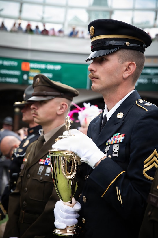 Spc. Brendan Hays and Staff Sgt. Jonathan Miller of the 617th Military Police Company escort the winner's trophy onto the Paddock at the 152nd running of the Kentucky Derby at Churchill Downs in Louisville, Kentucky, May 2, 2026.