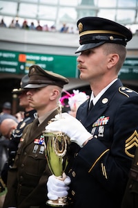 Spc. Brendan Hays and Staff Sgt. Jonathan Miller of the 617th Military Police Company escort the winner's trophy onto the Paddock at the 152nd running of the Kentucky Derby at Churchill Downs in Louisville, Kentucky, May 2, 2026.