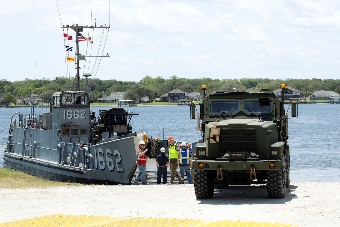 An up-armored MK36 Medium Tactical Vehicle Replacement wrecker rolls off a landing craft utility May 5, 2026, at Marine Corps Support Facility Blount Island in Jacksonville, Florida, during ship-to-shore operations supporting the 22nd Marine Expeditionary Unit (Special Operations Capable). The movement enabled rapid equipment transfer to sustain operations in the U.S. Southern Command area of responsibility. (U.S. Marine Corps photo by Dustin Senger)