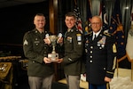 Indiana National Guard Sgt. Brendan Bartlett, a cyber specialist with the 147th Cyber Warfare Company, and Spc. Caleb Chambers, assigned to 1st Battalion, 151st Infantry Regiment, pose with their award for winning the highest overall combined score alongside Command Sgt. Maj. Mathew Hopkins, Michigan Army National Guard senior enlisted leader, after completing the Region IV Best Warrior Competition at Fort Custer Training Center, Michigan, May 2, 2026. The competition featured competitors from Michigan, Minnesota, Iowa, Ohio, Indiana, Illinois and Wisconsin. Photo by Staff Sgt. Hector Tinoco.