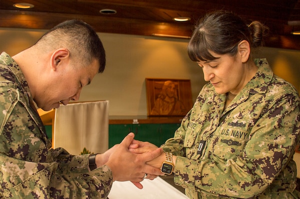 BREMERTON, Wash. – U.S. Navy Chaplain, Lt. Cmdr. Solomon Han, right, performs the traditional Blessing of the Hands ceremony for Navy Nurse Corps officer and civil service registered nurses assigned to Navy Medicine Readiness and Training Command/Naval Hospital Bremerton during National Nurses Week, May 6, 2026. The annual ceremony symbolizes the compassion, spiritual support, and dedication to patient care shared by Navy healthcare providers and the Chaplain Corps. The non-denominational ceremony, co-hosted by the command’s pastoral care team and nursing leadership, was open to all military and civilian nursing staff. The blessing symbolizes spiritual strength, human compassion, and dedication to patient care shared by U.S. Navy clinicians and the Chaplain Corps, reaffirming the command’s commitment to holistic healing and the well-being of the entire medical team as part of mission readiness.(official Navy photo by Mass Communication Specialist 1st Class Jennifer Benedict, Public Affairs, NHB/NMRTC Bremerton).