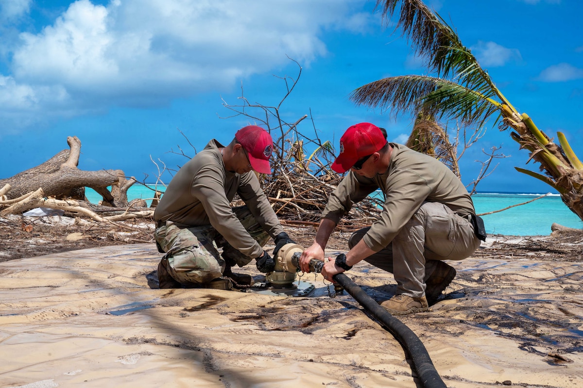 Tech. Sgt. Carlo Velasco and Staff Sgt. Christopher Gutierrez, 554th RED HORSE Squadron, connects a hose to a Reverse Osmosis Water Purification Unit at Pao Pao Beach, Saipan, April 28, 2026. The system provided potable water in support of Typhoon Sinlaku relief efforts. (U.S. Air Force photo by Senior Airman Manasseh Demissie)
