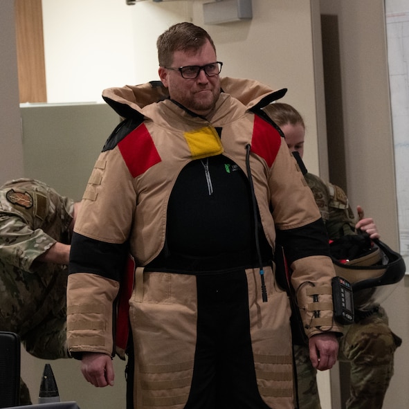 A Community Leadership Institute (CLI) member tries on an explosive ordnance disposal (EOD) bomb suit at Minot Air Force Base, North Dakota, April 30, 2026. The CLI members were given an opportunity to learn about the EOD mission while on a guided tour around base. (U.S. Air Force photo by Airman Ben Selchow)