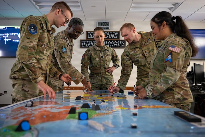 A group of service members conduct military planning.