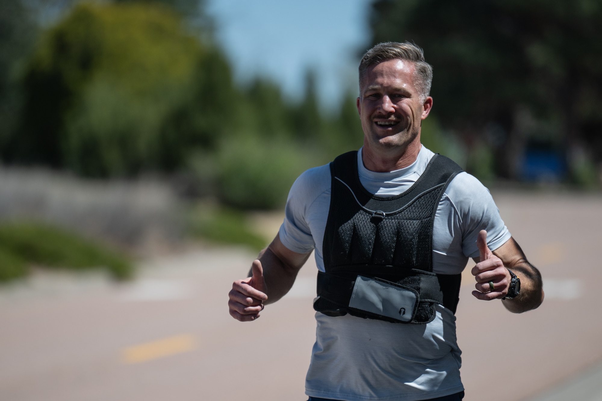 An Airman gives a thumbs up as he jogs by.