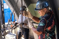 Ronald Gorgonio, a production controller and participant with EDP Cadre A 2026 at Pearl Harbor Naval Shipyard and Intermediate Maintenance Facility lowers a pipe using a chain-fall during a training exercise at the Learning Center on March 24, 2026.
