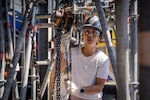 Leslie Bovaird, lead nuclear engineer and Executive Leadership Development (EDP) Cadre A 2026 participant at Pearl Harbor Naval Shipyard and Intermediate Maintenance Facility lowers a pipe using a chain-fall during a training exercise at the Learning Center on March 24, 2026. The exercise provides a glimpse into the multi-year training pipeline that develops skilled riggers and gives future leaders a perspective of the craft that is a staple of shipyard life.