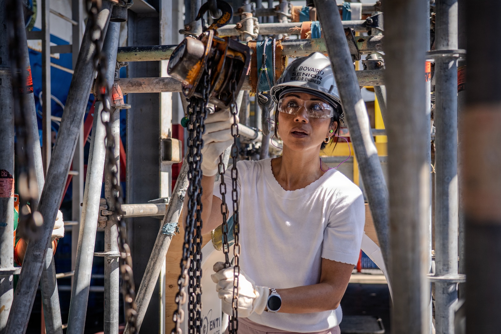 Leslie Bovaird, lead nuclear engineer and Executive Leadership Development (EDP) Cadre A 2026 participant at Pearl Harbor Naval Shipyard and Intermediate Maintenance Facility lowers a pipe using a chain-fall during a training exercise at the Learning Center on March 24, 2026. The exercise provides a glimpse into the multi-year training pipeline that develops skilled riggers and gives future leaders a perspective of the craft that is a staple of shipyard life.