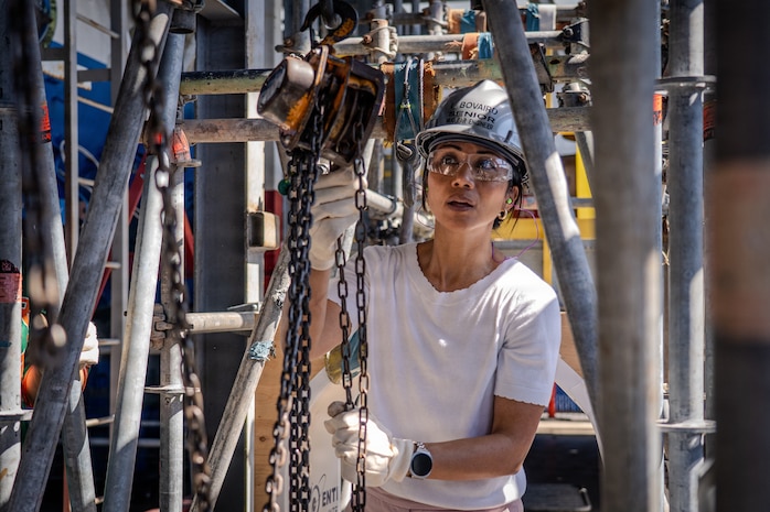 Leslie Bovaird, lead nuclear engineer and Executive Leadership Development (EDP) Cadre A 2026 participant at Pearl Harbor Naval Shipyard and Intermediate Maintenance Facility lowers a pipe using a chain-fall during a training exercise at the Learning Center on March 24, 2026. The exercise provides a glimpse into the multi-year training pipeline that develops skilled riggers and gives future leaders a perspective of the craft that is a staple of shipyard life.
