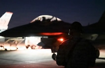 A U.S. Air Force Airman assigned to the 31st Combat Air Base Squadron marshals aircraft for night flying operations during exercise Freedom Flag 26-1 at Gwangju Air Base, Republic of Korea, April 20, 2026. The cross-functional teams that make up the 31st CABS enhance operational flexibility and ensure mission continuity. (U.S. Air Force photo by 2nd Lt. Daniel White)